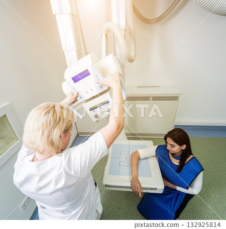 Radiologist and patient in a x-ray room. X-ray of human hand. Radiologist and patient in a x-ray room. X-ray of human hand. 132925814