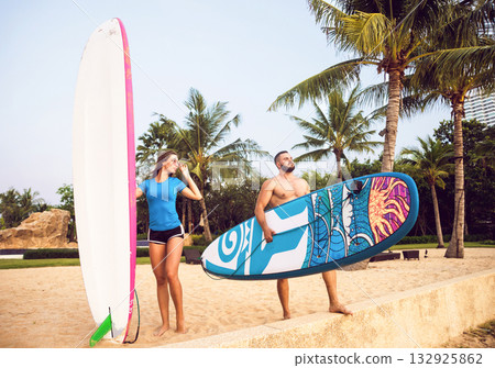Two young surfers with boards on the beach 132925862