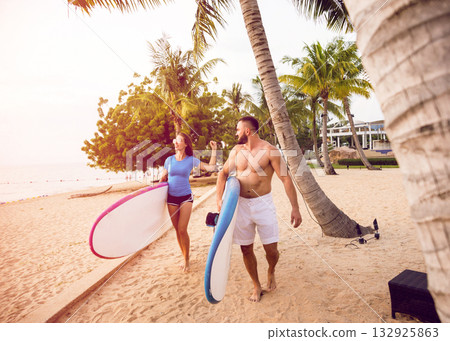 Two young surfers with boards on the beach 132925863