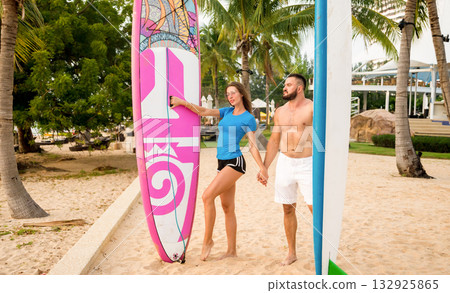 Two young surfers with boards on the beach Two young surfers with boards on the beach 132925865