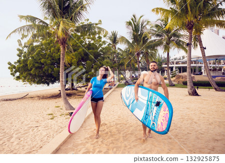 Two young surfers with boards on the beach 132925875