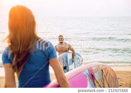 Two young surfers going into the sea with surf boards Two young surfers going into the sea with surf boards 132925888