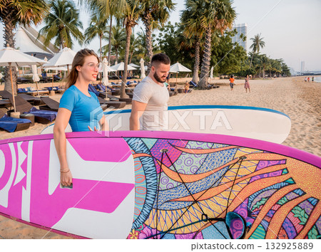 Two young surfers going into the sea with surf boards Two young surfers going into the sea with surf boards 132925889