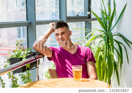 Young man in the pub. Drinking beer, eating pizza. 132925897