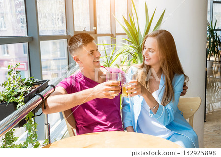 Cheerful couple in the pub. Drinking beer, talking, having fun. 132925898