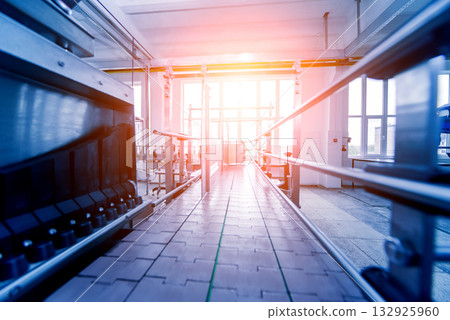 Automatic filling machine pours water into plastic PET bottles.  132925960