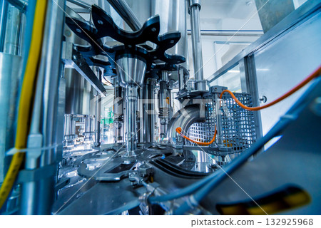 Automatic filling machine pours water into plastic PET bottles. Automatic filling machine pours water into plastic PET bottles. 132925968