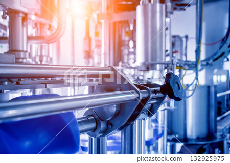 Automatic filling machine pours water into plastic PET bottles. Automatic filling machine pours water into plastic PET bottles. 132925975