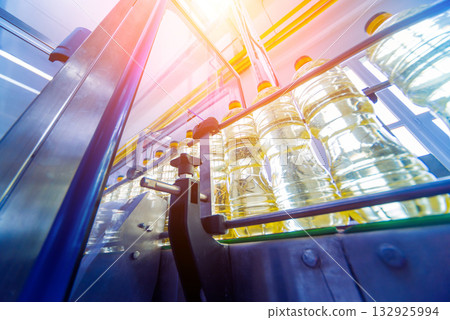 Bottling line of sunflower oil in bottles. Vegetable oil production plant Bottling line of sunflower oil in bottles. Vegetable oil production plant 132925994