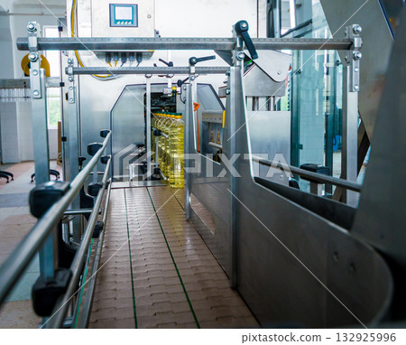 Bottling line of sunflower oil in bottles. Vegetable oil production plant. Bottling line of sunflower oil in bottles. Vegetable oil production plant. 132925996