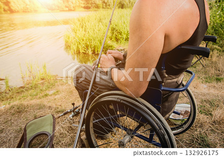 Handicapped man fishing at a lake. Wheelchair camping. 132926175