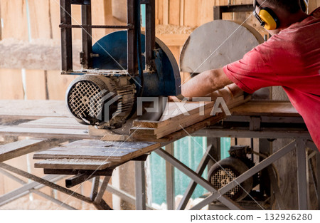 Modern sawmill. A carpenter works on woodworking the machine tool. Modern sawmill. A carpenter works on woodworking the machine tool. 132926280