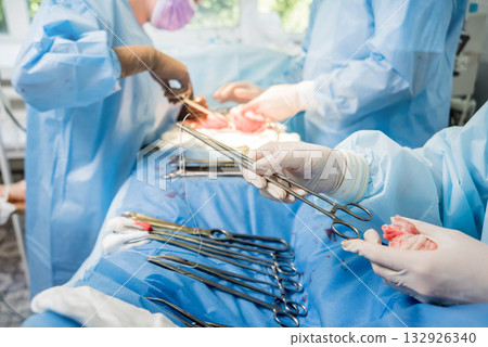 Surgeon and assistants in operating room with surgery equipment. Surgeon and assistants in operating room with surgery equipment. 132926340