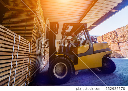 Forklift loader load lumber into a dry kiln. Wood drying in containers. 132926378