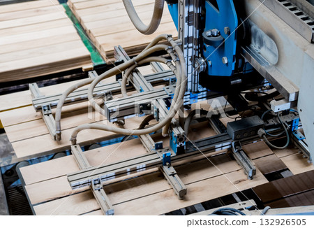 Production line of the wooden floor factory. CNC automatic woodworking machine. 132926505