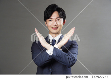 Businessman making a cross gesture on a black background Businessman making a cross gesture on a black background 132927755