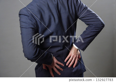 Businessman back pain back view black background Businessman back pain back view black background 132927783