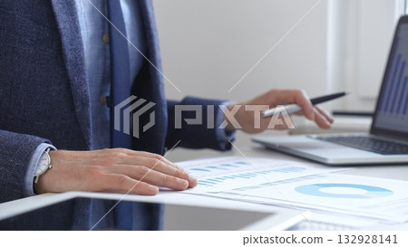 Businessman analyzing financial charts on laptop, reviewing data for strategic business planning. Business people concept Businessman analyzing financial charts on laptop, reviewing data for strategic business planning. Business people concept 132928141