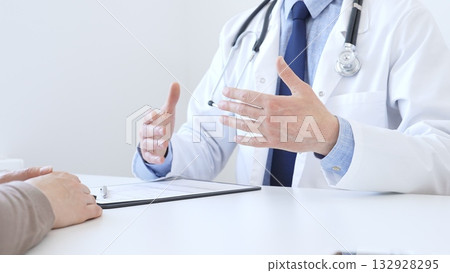 Adult doctor gesturing with hands while explaining diagnosis to patient during medical consultation in hospital office, healthcare and medical concept. Medicine concept Adult doctor gesturing with hands while explaining diagnosis to patient during medical consultation in hospital office, healthcare and medical concept. Medicine concept 132928295