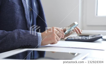 Financial analyst reviewing accounting reports, calculating data with calculator and magnifying glass on corporate workspace. Audit and taxes in business Financial analyst reviewing accounting reports, calculating data with calculator and magnifying glass on corporate workspace. Audit and taxes in business 132928304