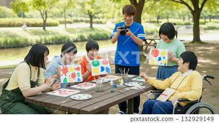 Residents and support staff enjoying creative activities outdoors surrounded by greenery - Daily life at a facility for people with disabilities - Drawing - Creative activities - Art 132929149