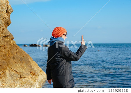 Mature Russian woman taking selfie by the Japan Sea in Vladivostok. Stylish traveler sharing her cold season journey on social media. Mature Russian woman taking selfie by the Japan Sea in Vladivostok. Stylish traveler sharing her cold season journey on social media. 132929318