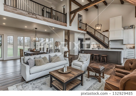 Spacious luxurious home interiors feature modern staircase, wooden beams, a comfortable living room, and open kitchen 132929485