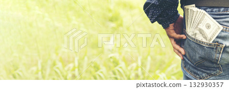 Banner Backside Businessman spreading 100 dollar banknote back jeans pocket. Hand holding money dollar bank note. Banner Man hands spread 100 dollar exchange cash with copy space. Bribe corruption 132930357