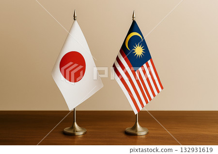 Japanese and Malaysian flags lined up on a desk 132931619