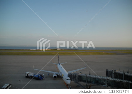 海濱機場航廈的景象,一架飛機與一輛加油車相連。 海濱機場航廈的景象,一架飛機與一輛加油車相連。 132931774