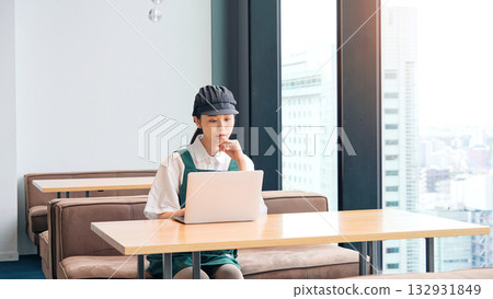 Restaurant clerk entering data on a laptop Restaurant clerk entering data on a laptop 132931849