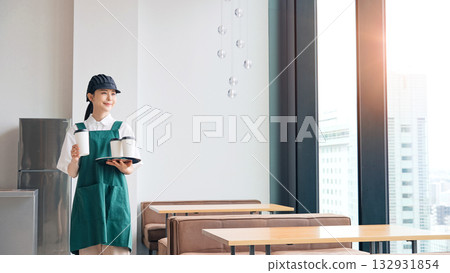 Smiling restaurant employee holding a paper cup 132931854