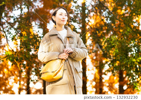 Woman enjoying autumn leaves lifestyle image Woman enjoying autumn leaves lifestyle image 132932230