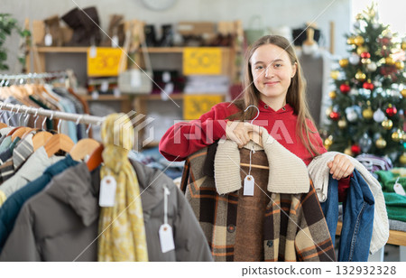 In sales area of store during Christmas sale, teen girl customer choose plaid jacket In sales area of store during Christmas sale, teen girl customer choose plaid jacket 132932328
