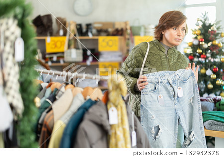 Adult woman choosing jeans in clothing store Adult woman choosing jeans in clothing store 132932378