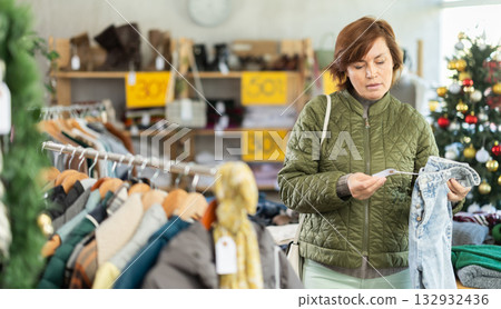 Adult woman choosing jeans in clothing store Adult woman choosing jeans in clothing store 132932436