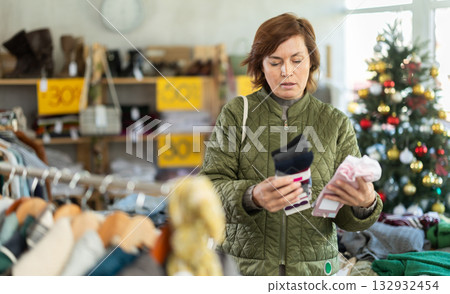 Woman picks up clothes and chooses socks, New Year Eve sale Woman picks up clothes and chooses socks, New Year Eve sale 132932454