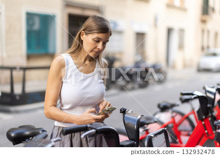 Woman pays for rental bicycle use with QR code 132932478