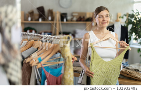 Adult woman choosing top in clothing store Adult woman choosing top in clothing store 132932492