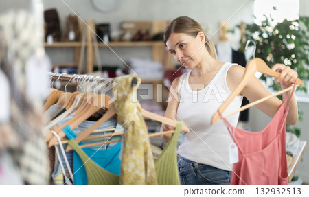 Adult woman choosing jumpsuit in clothing store Adult woman choosing jumpsuit in clothing store 132932513