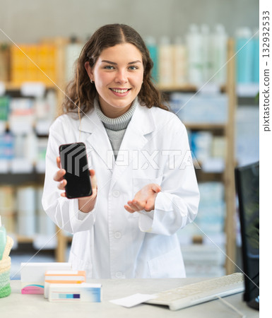 Female pharmacist offers to download app on smartphone Female pharmacist offers to download app on smartphone 132932533