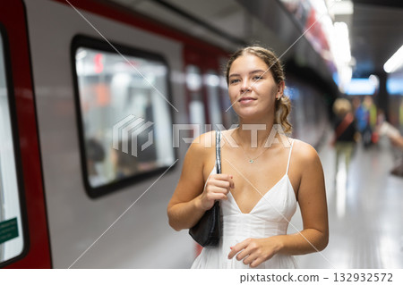 Young woman standing on platform waiting for train Young woman standing on platform waiting for train 132932572