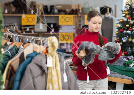 Teenage girl choosing hat in clothing store 132932719
