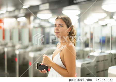 Thoughtful young girl passing through terminal in subway station 132932858