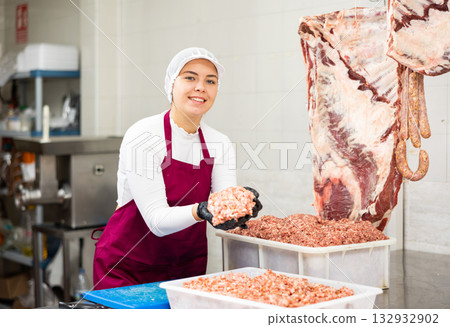 Young female butcher preparing minced meat for sale Young female butcher preparing minced meat for sale 132932902