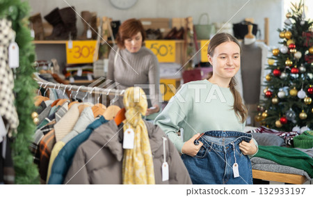 Teenage girl choosing jeans in clothing store Teenage girl choosing jeans in clothing store 132933197