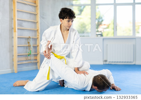 Man and teenage boy train judo fighting techniques Man and teenage boy train judo fighting techniques 132933365