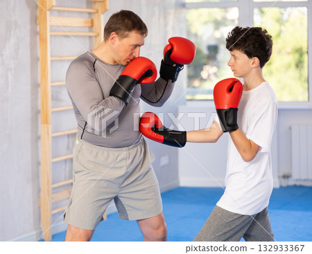 Man and boy teenager train boxing in studio Man and boy teenager train boxing in studio 132933367