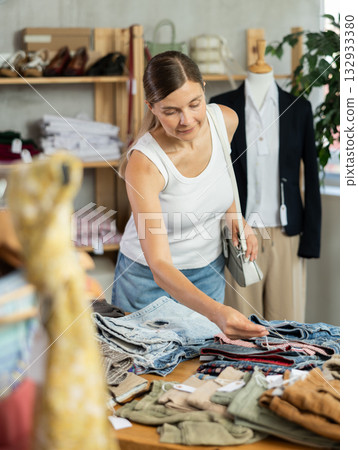 Adult woman choosing jeans in clothing store Adult woman choosing jeans in clothing store 132933380