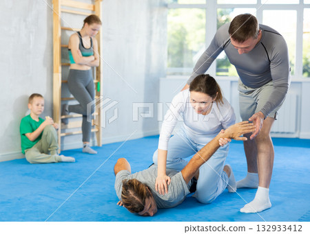 Woman student, with help of male teacher, completes neutralization of opponent Woman student, with help of male teacher, completes neutralization of opponent 132933412